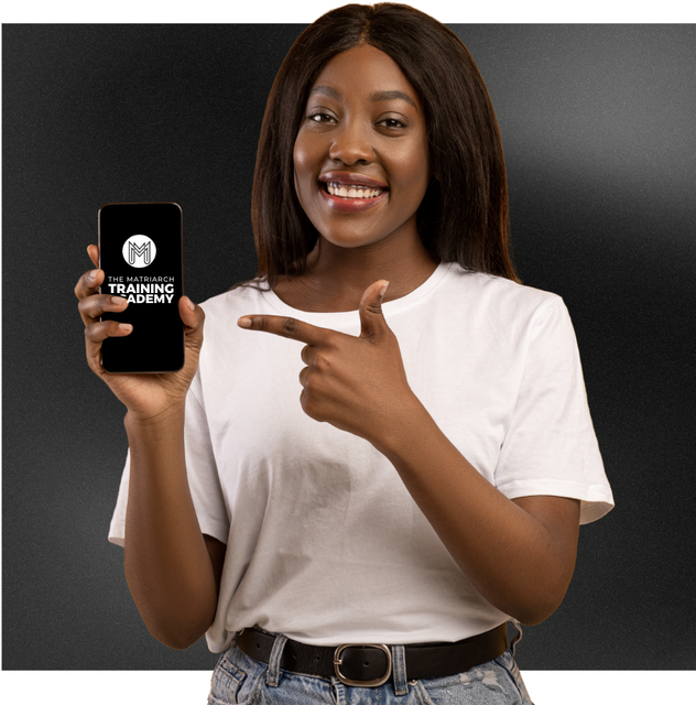 Smiling woman in a white shirt holding up a phone displaying the Matriarch Training Academy logo, pointing at the screen.